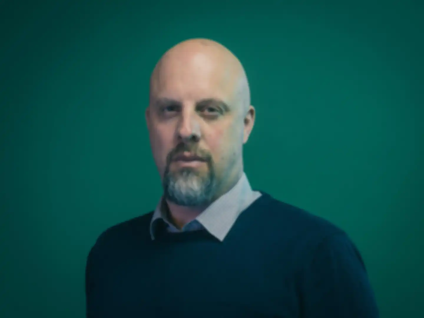 Portrait von Patrick Rose, Innovationsmanager bei der SPRIND, vor grünem monochromen Hintergrund.