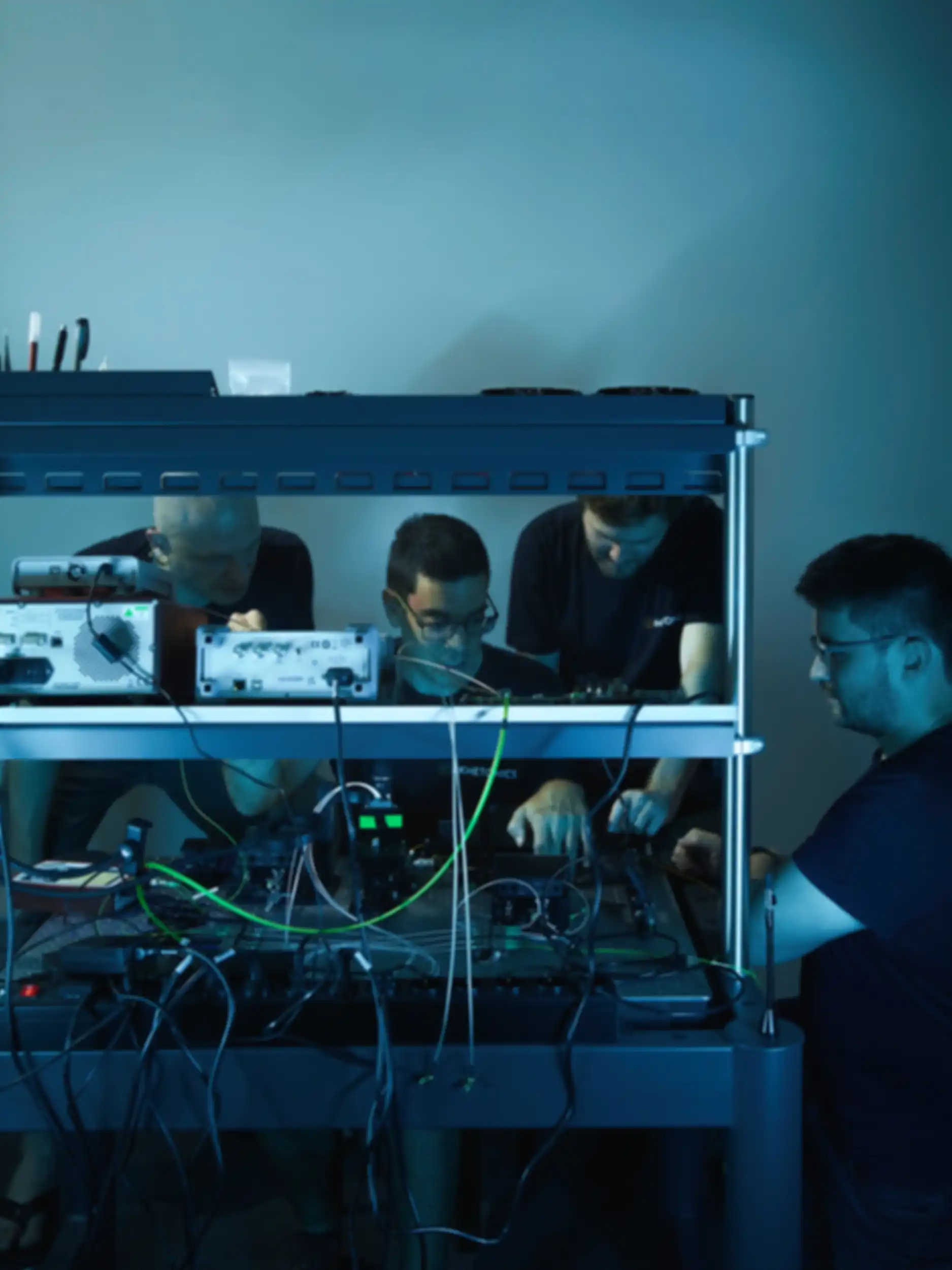 Four men in a meeting in front of a technical setup