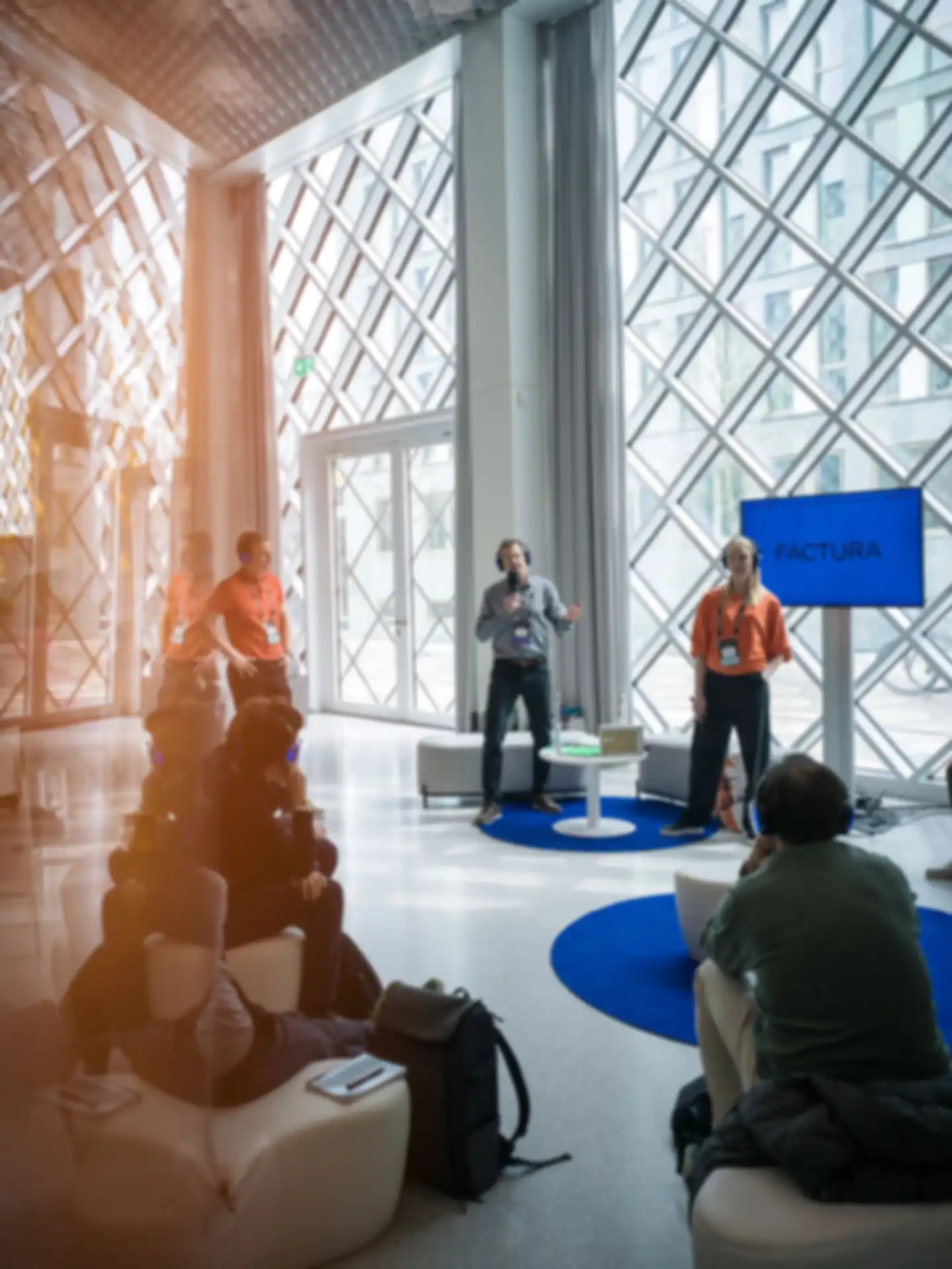 Three people are giving a presentation surrounded by an audience