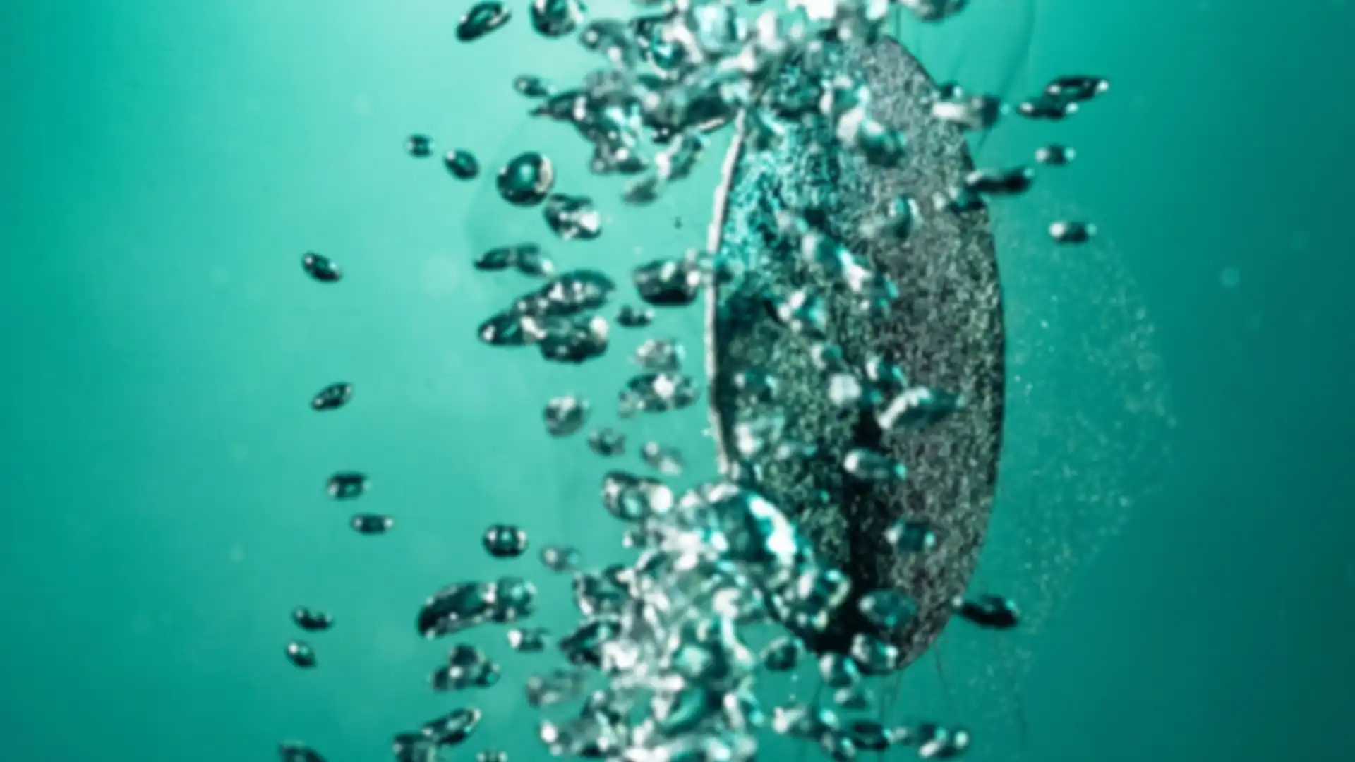 Abstrakte Darstellung einer strukturierten Materialoberfläche mit schwebenden Wassertropfen vor türkisfarbenem Hintergrund.