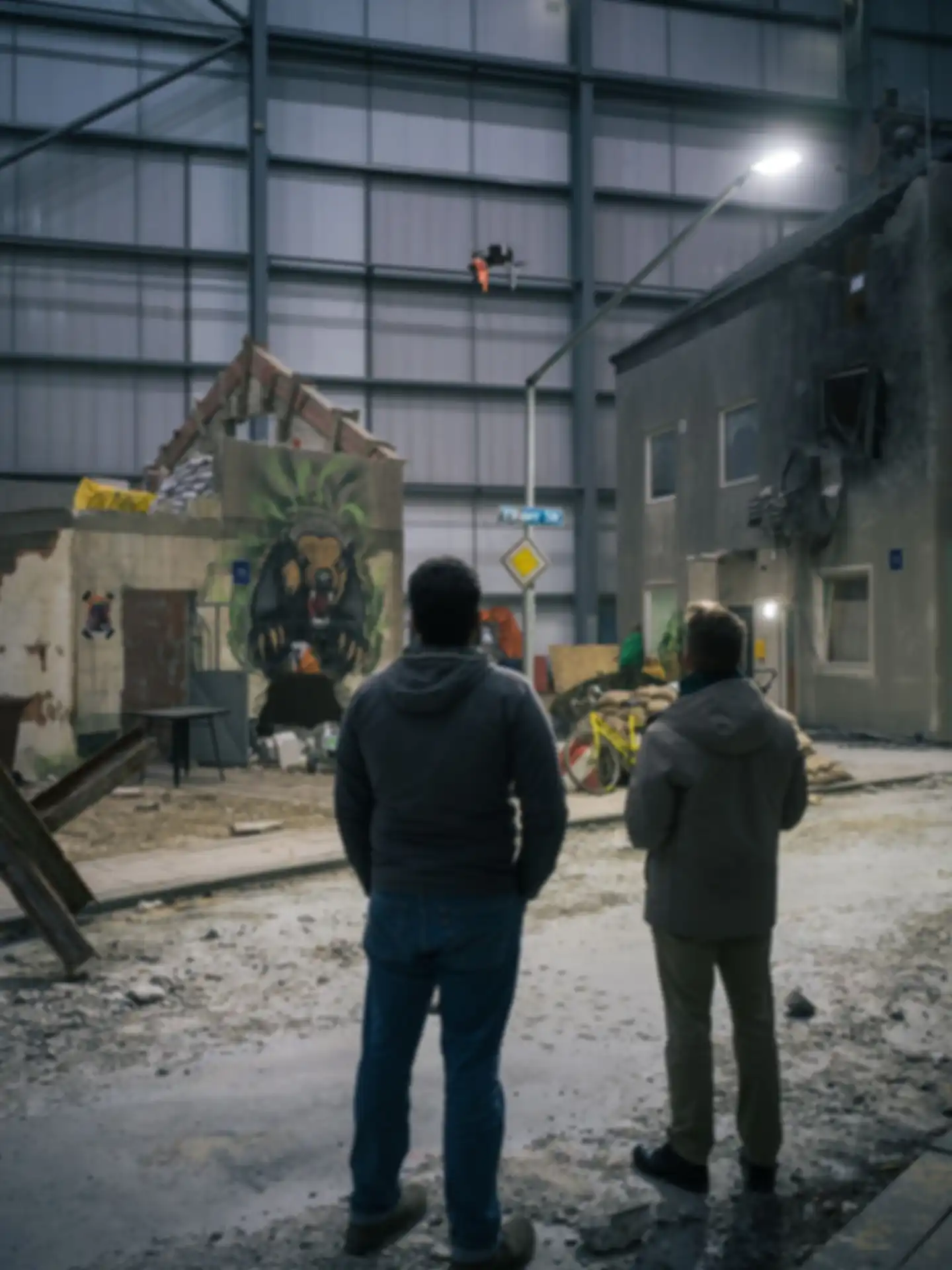 Two people are watching a drone fly over the test site.