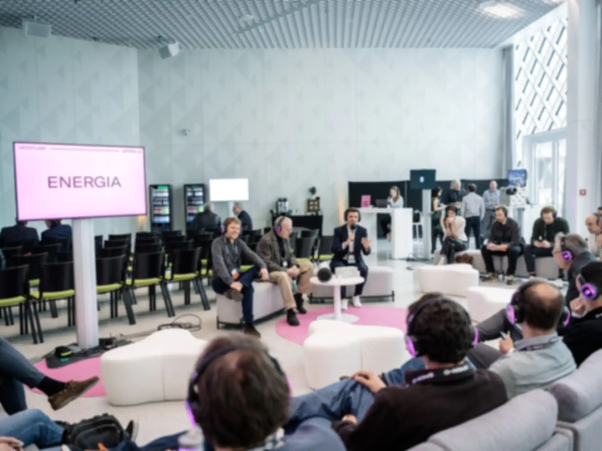 Three people are giving a presentation while surrounded by an audience