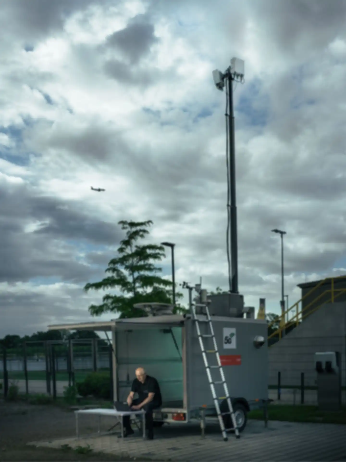 Ein Anhänger mit langer ausgefahrener Antenne. Ein Person sitzt im Anhänger
