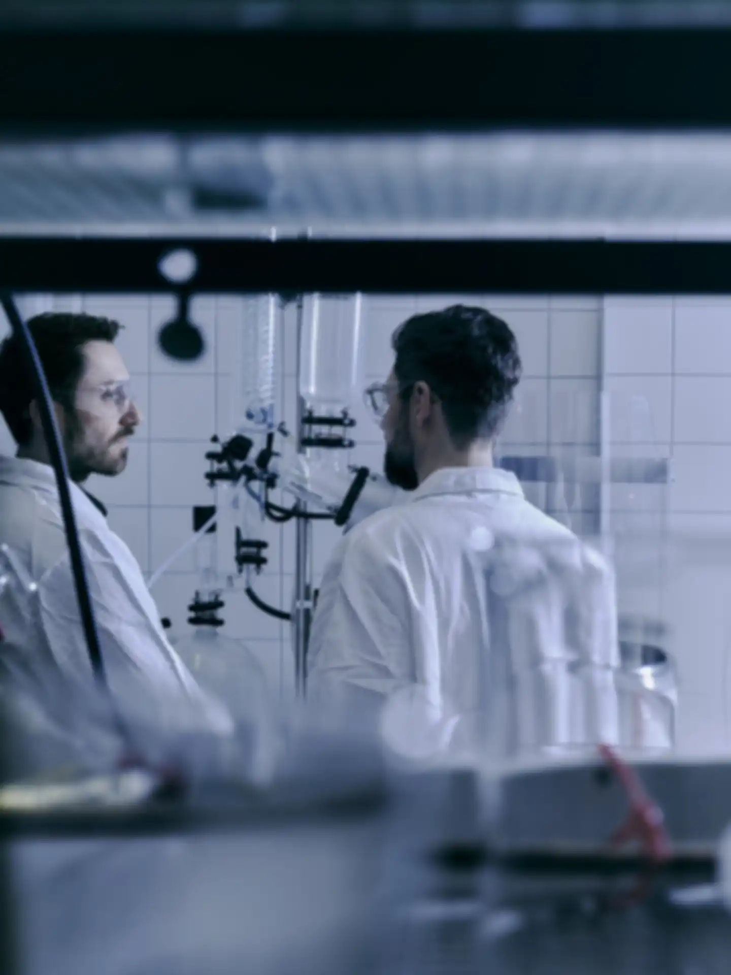 Two men in lab coats talking