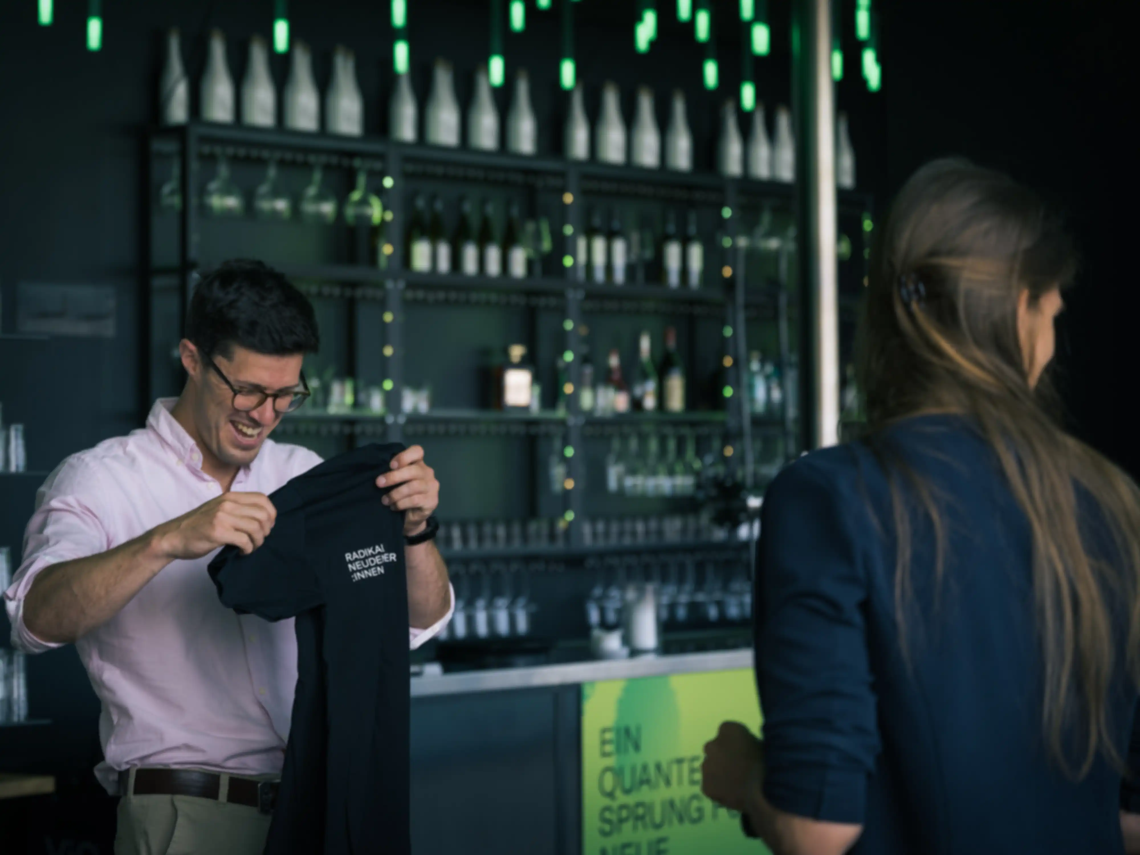 A man is handed a T-shirt by a woman