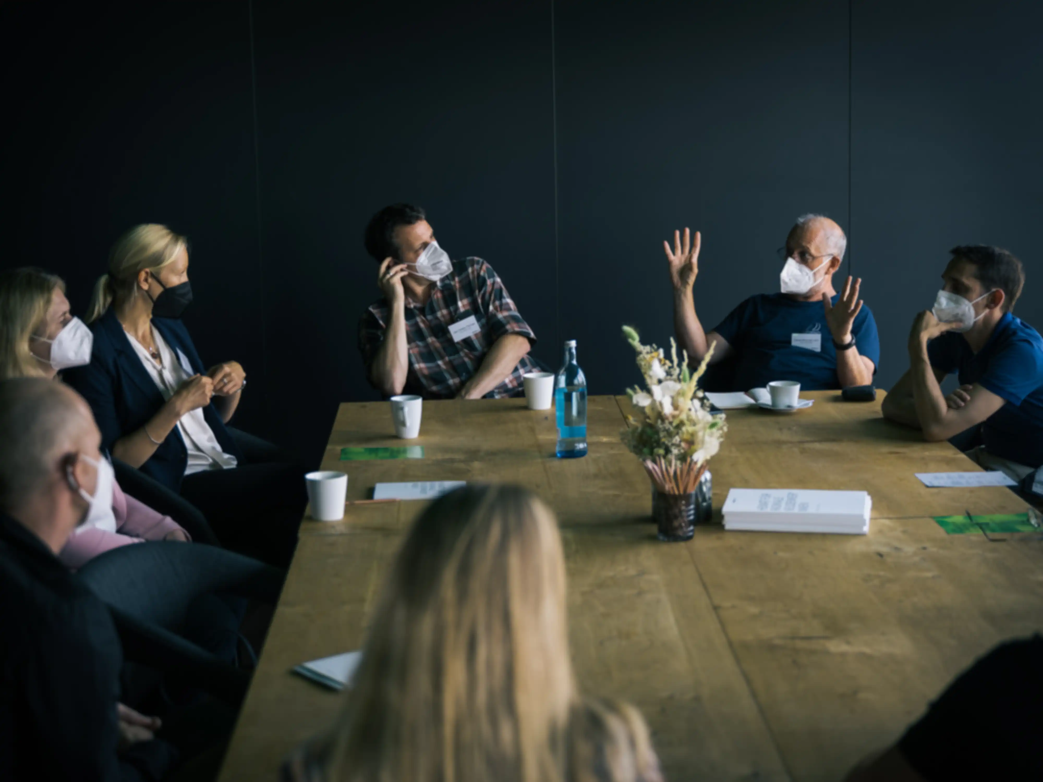 Several people in a meeting gathered around a table