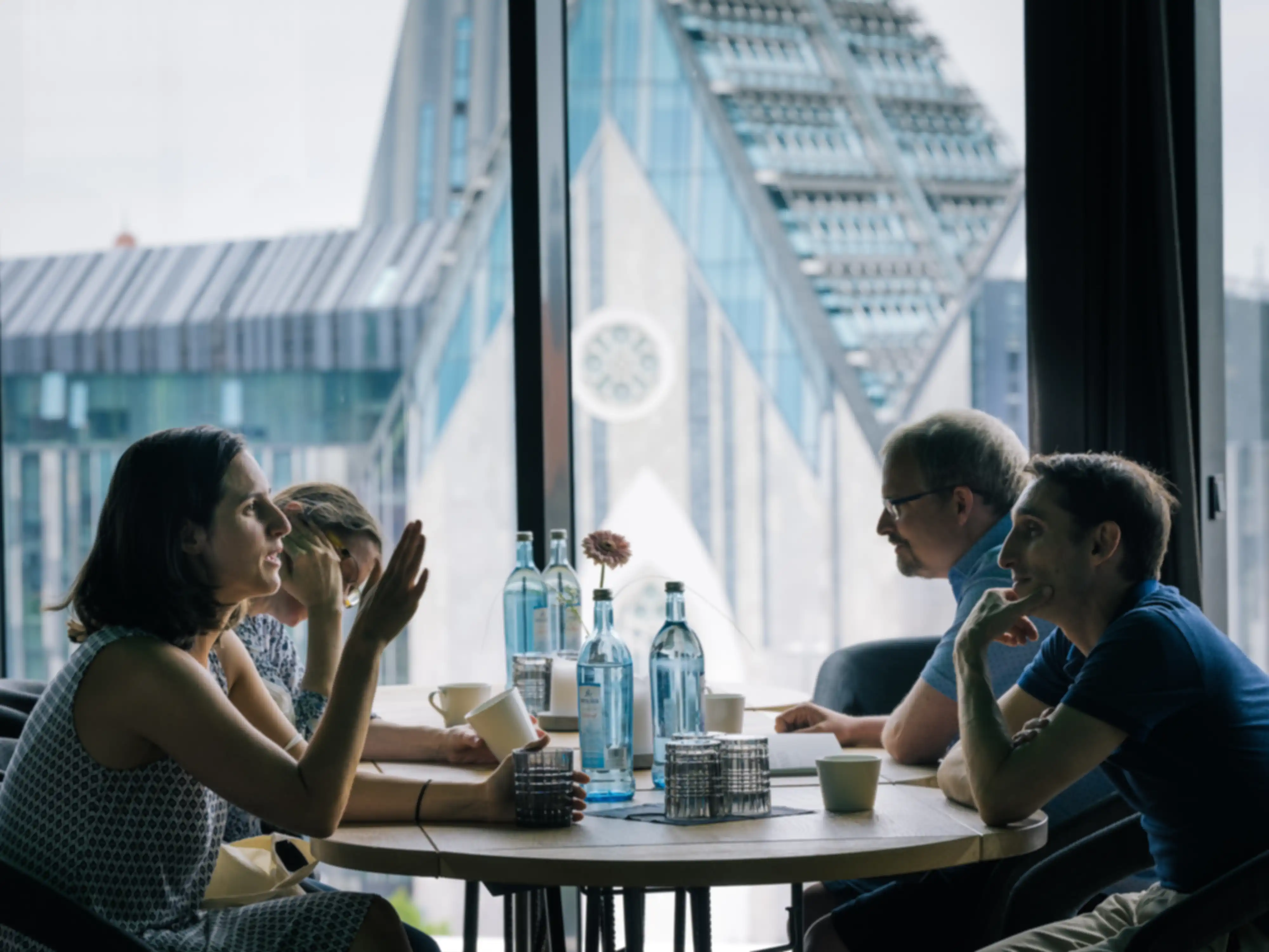 Four people are sitting at a table and talking