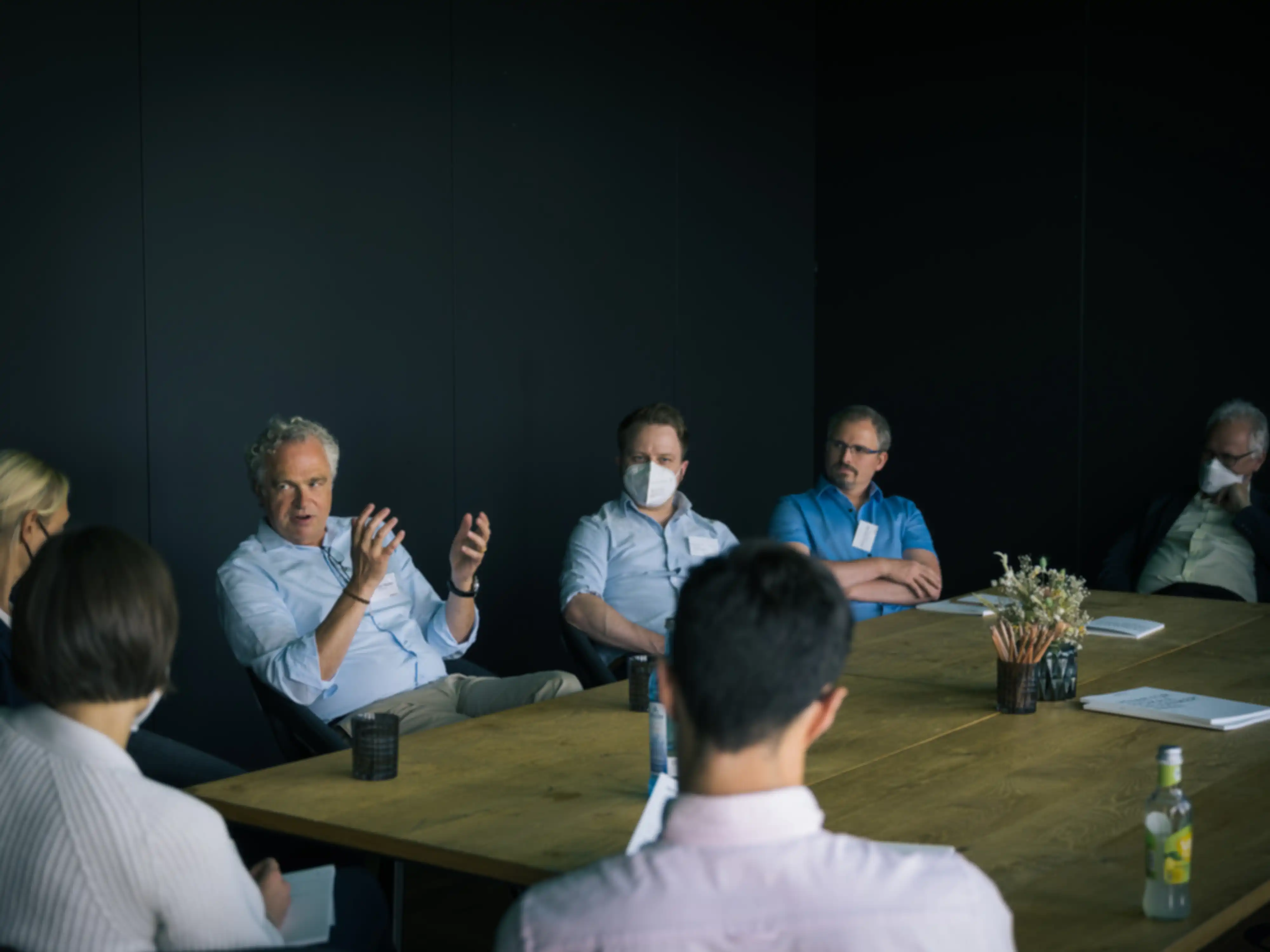 Several people in a meeting gathered around a table