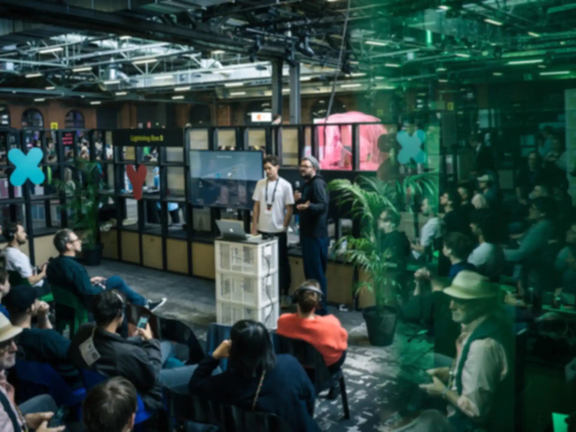 Two people are giving a presentation to an audience at a science fair booth