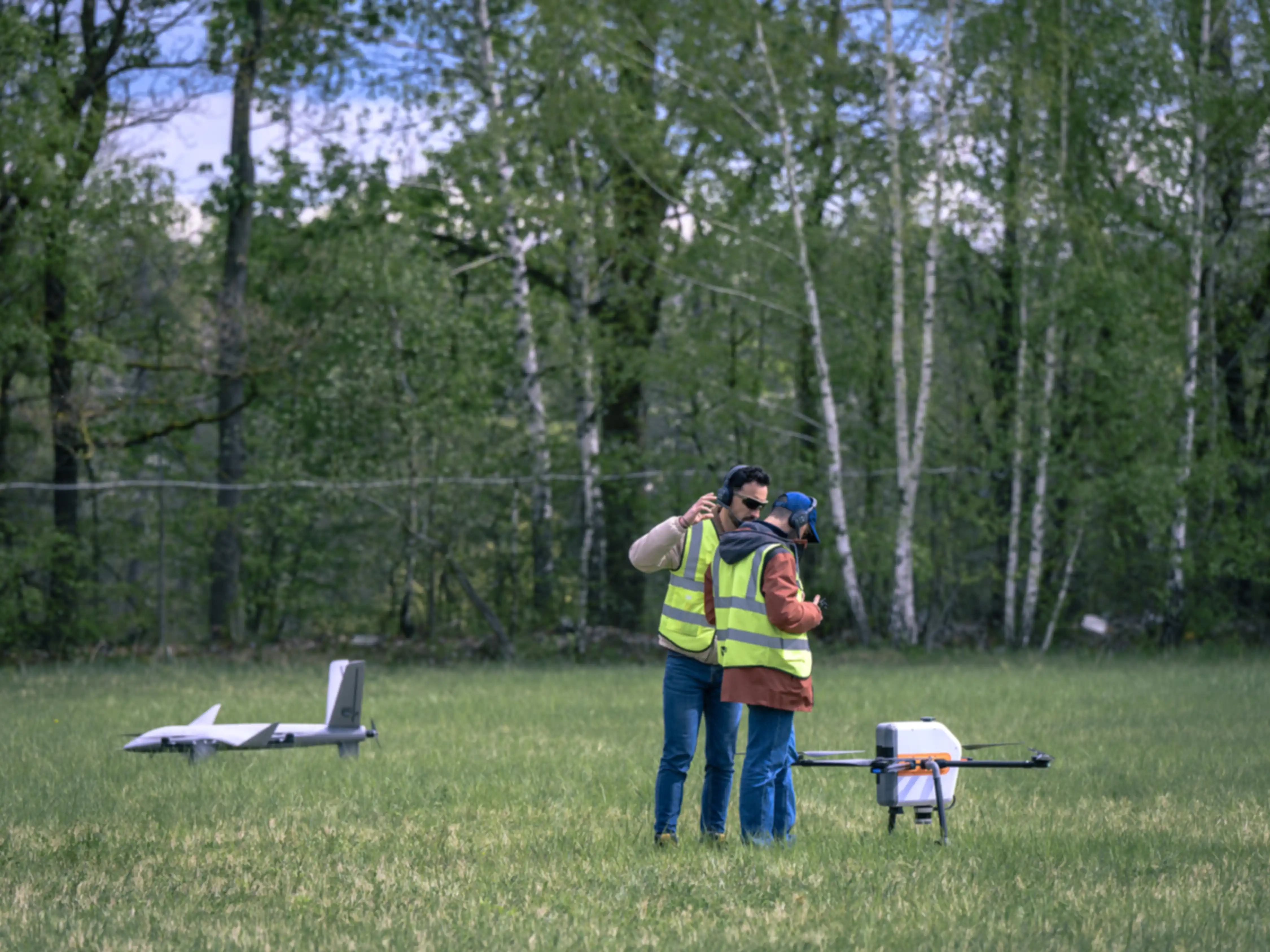 A team with their drone on a grassy field