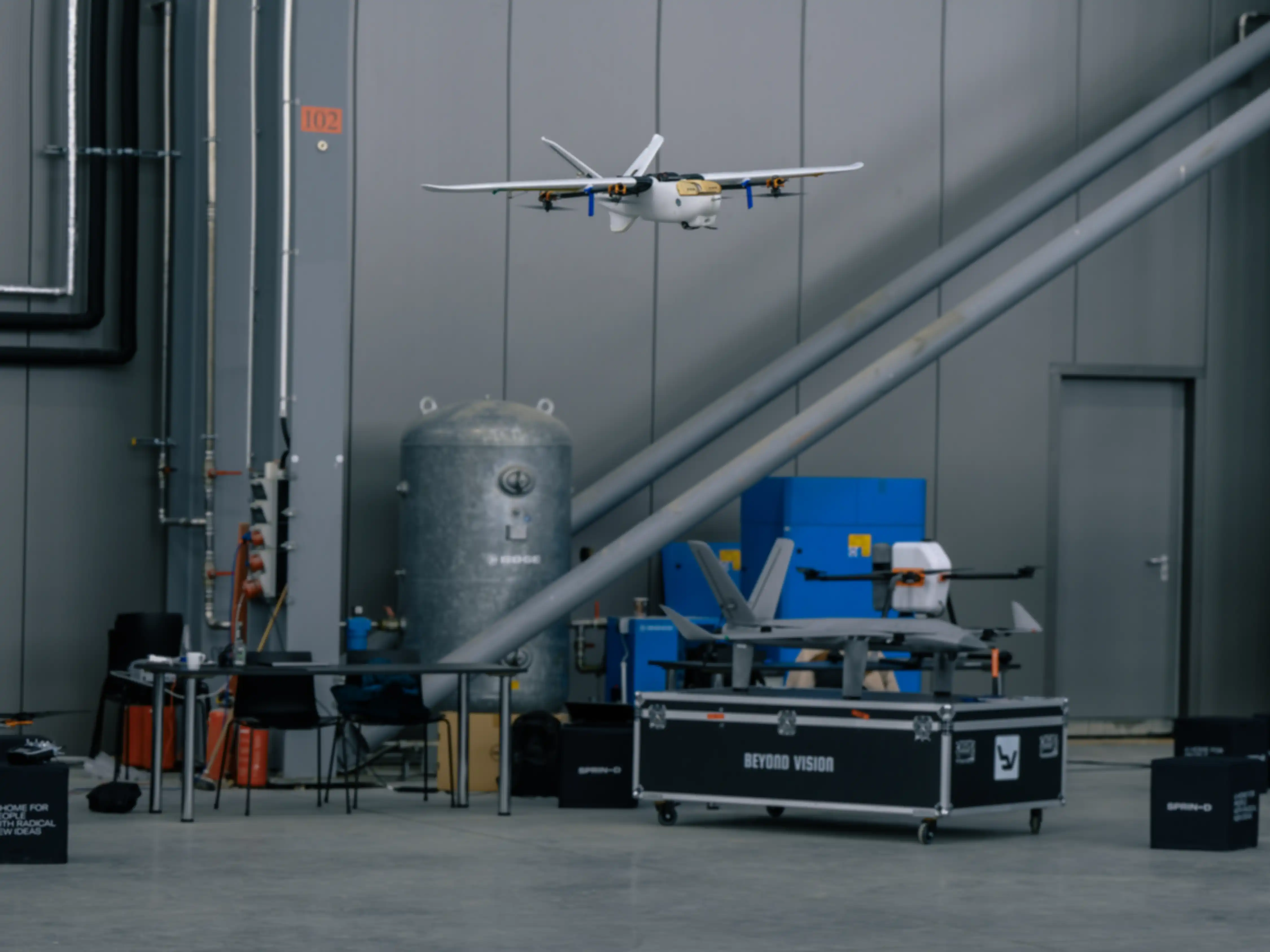 A drone on a test flight inside a hangar