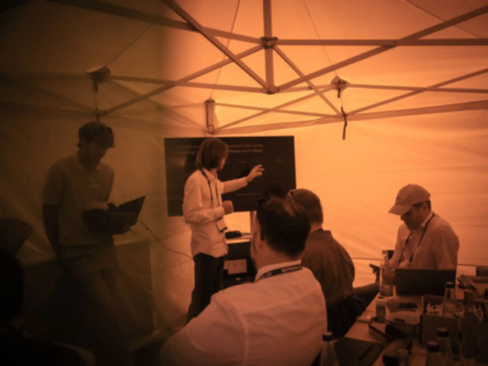 Fünf Männer diskutieren unter einem Pavillon
