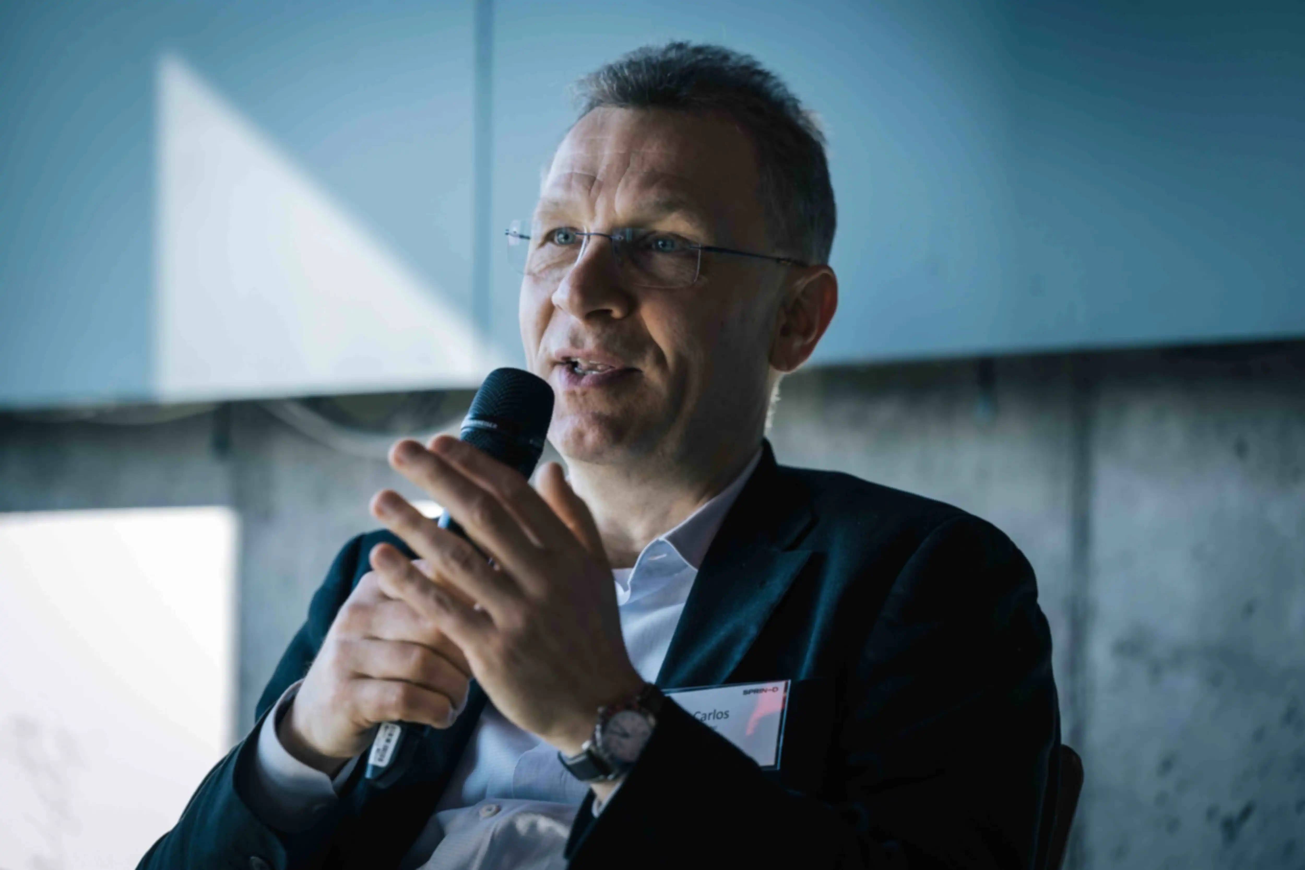Eine Nahaufnahme einer Person mit Mikrofon, während eines Vortrags