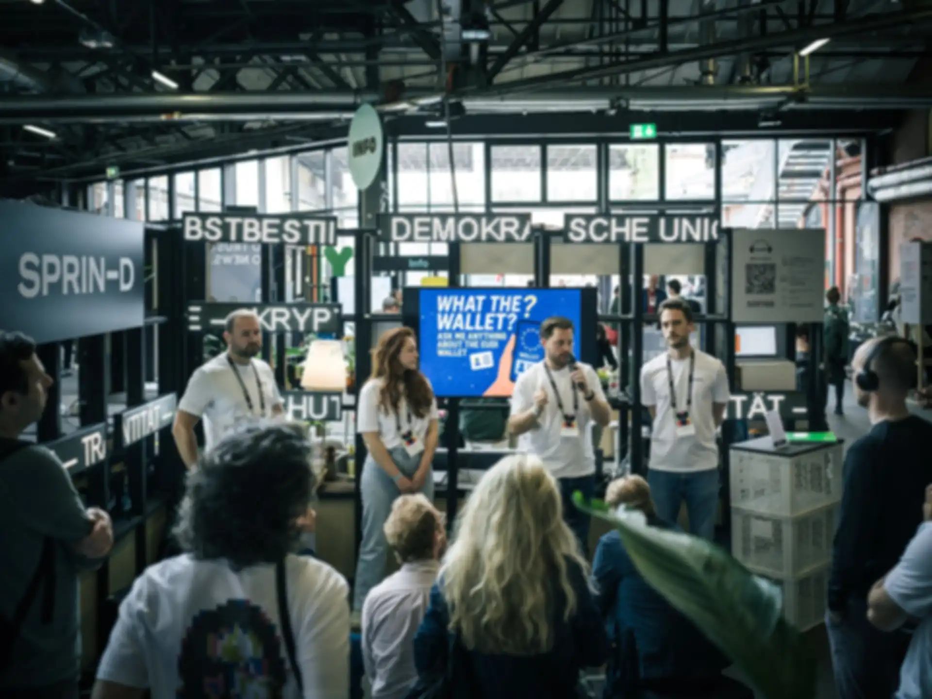 Four people are giving a presentation at a booth during the trade show