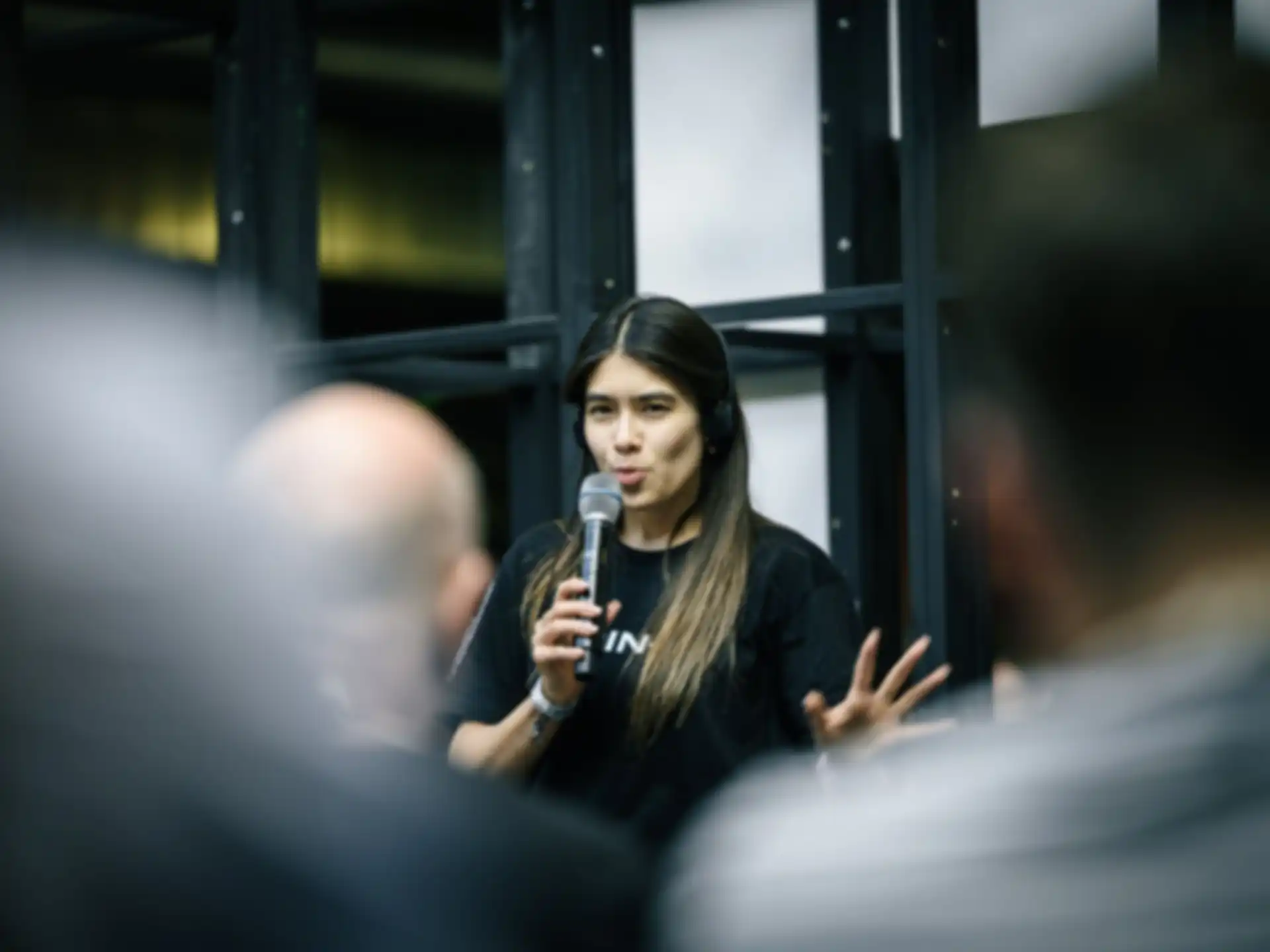 A person is giving a presentation. The audience is out of focus.