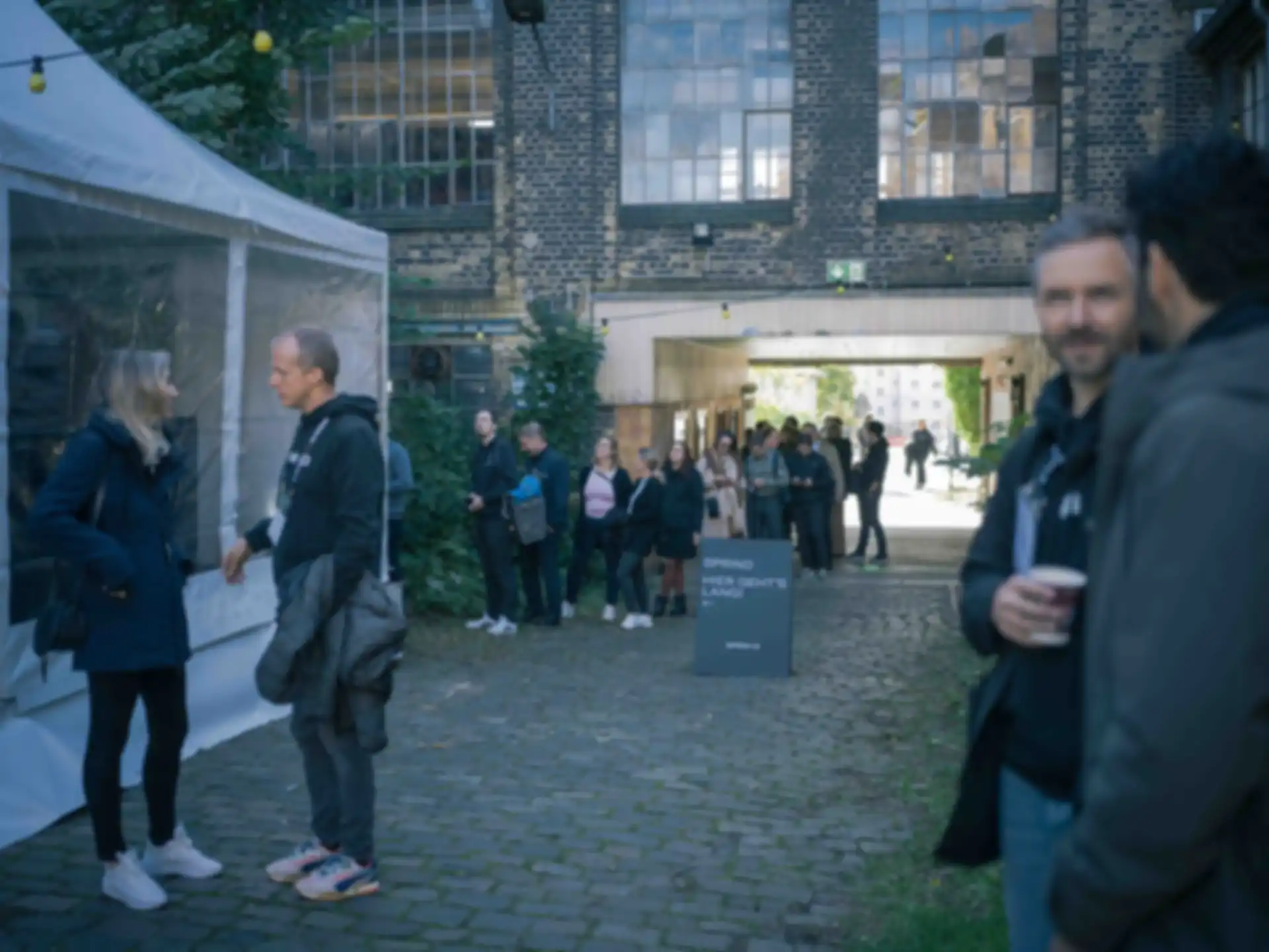 Mehrere Personen im Außenbereich des Events im Gespräch
