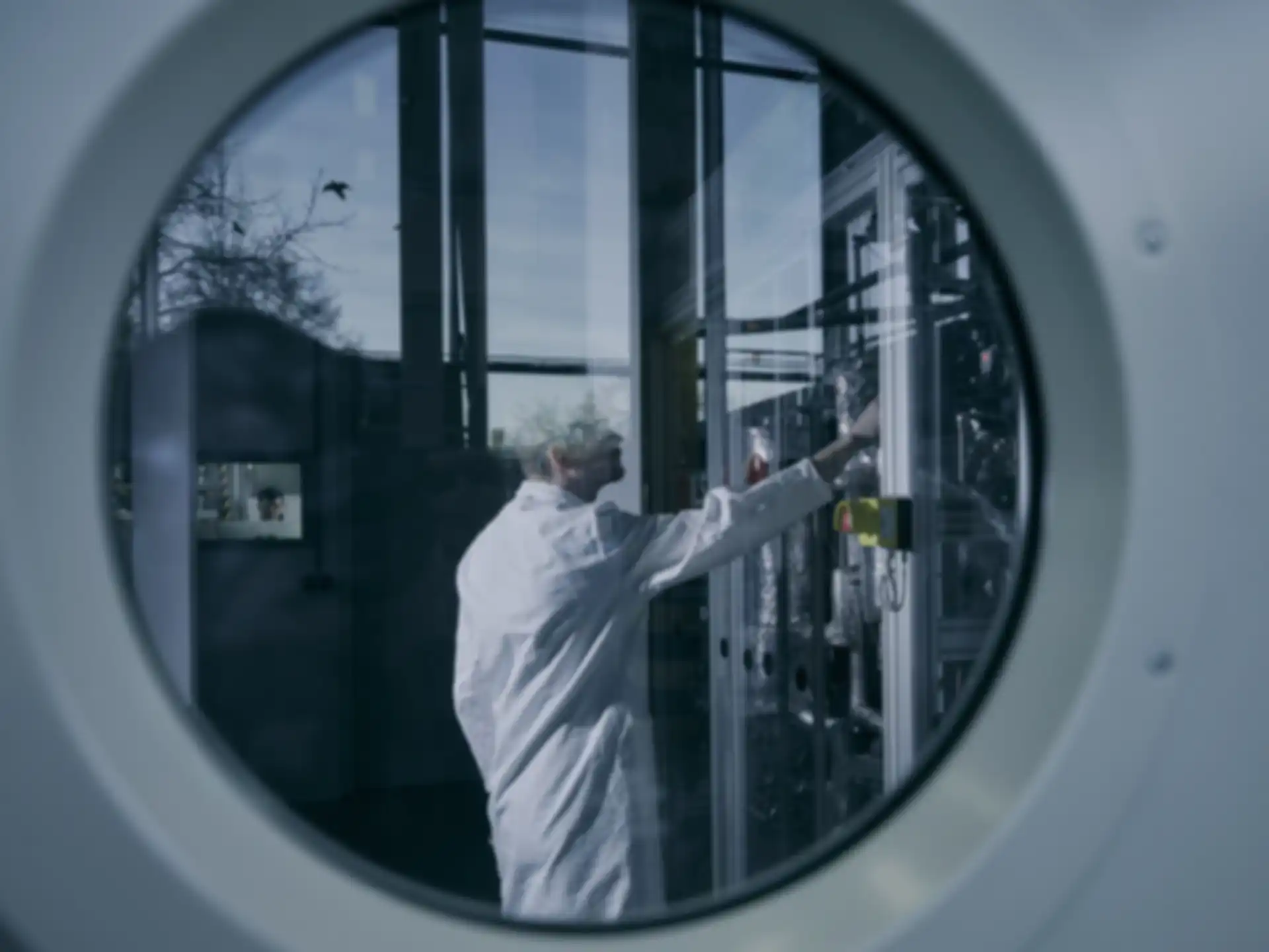 A man in a laboratory is shown through a window in a door