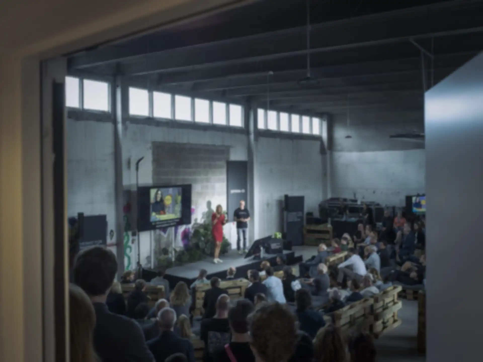Zwei Personen halten einen Vortrag einer Halle