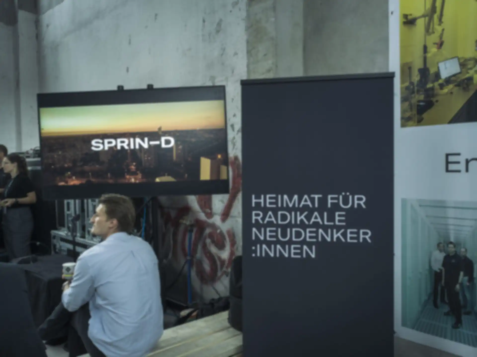 Ein Bildschirm mit dem SPRIND Logo und ein Banner dem SPRIND Slogan