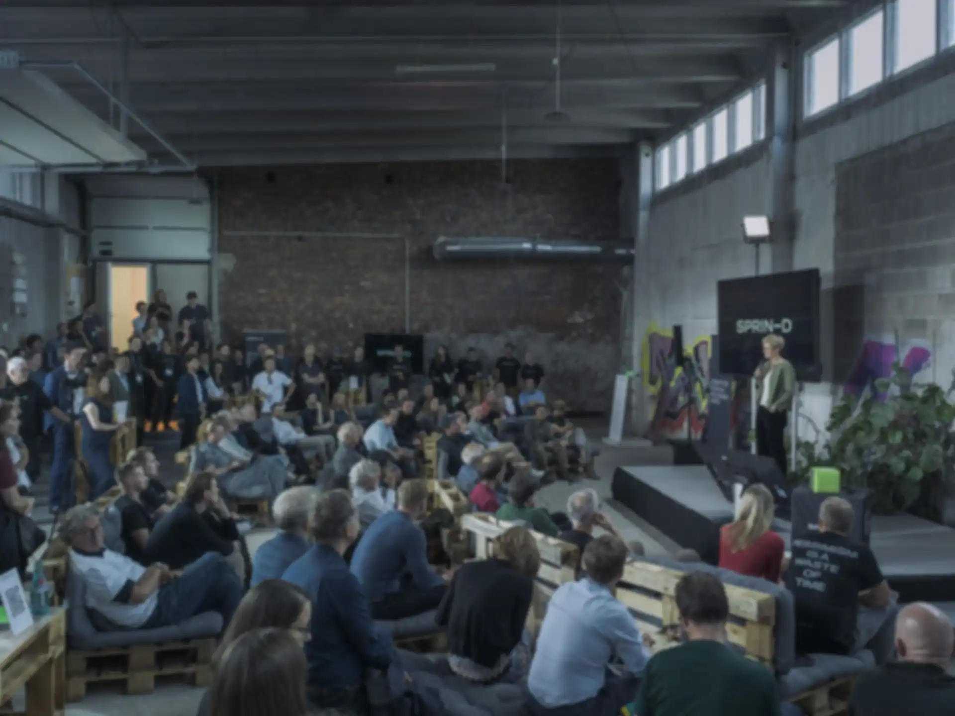 Berit Dannenberg, from SPRIND, welcomes the guests in a hall.