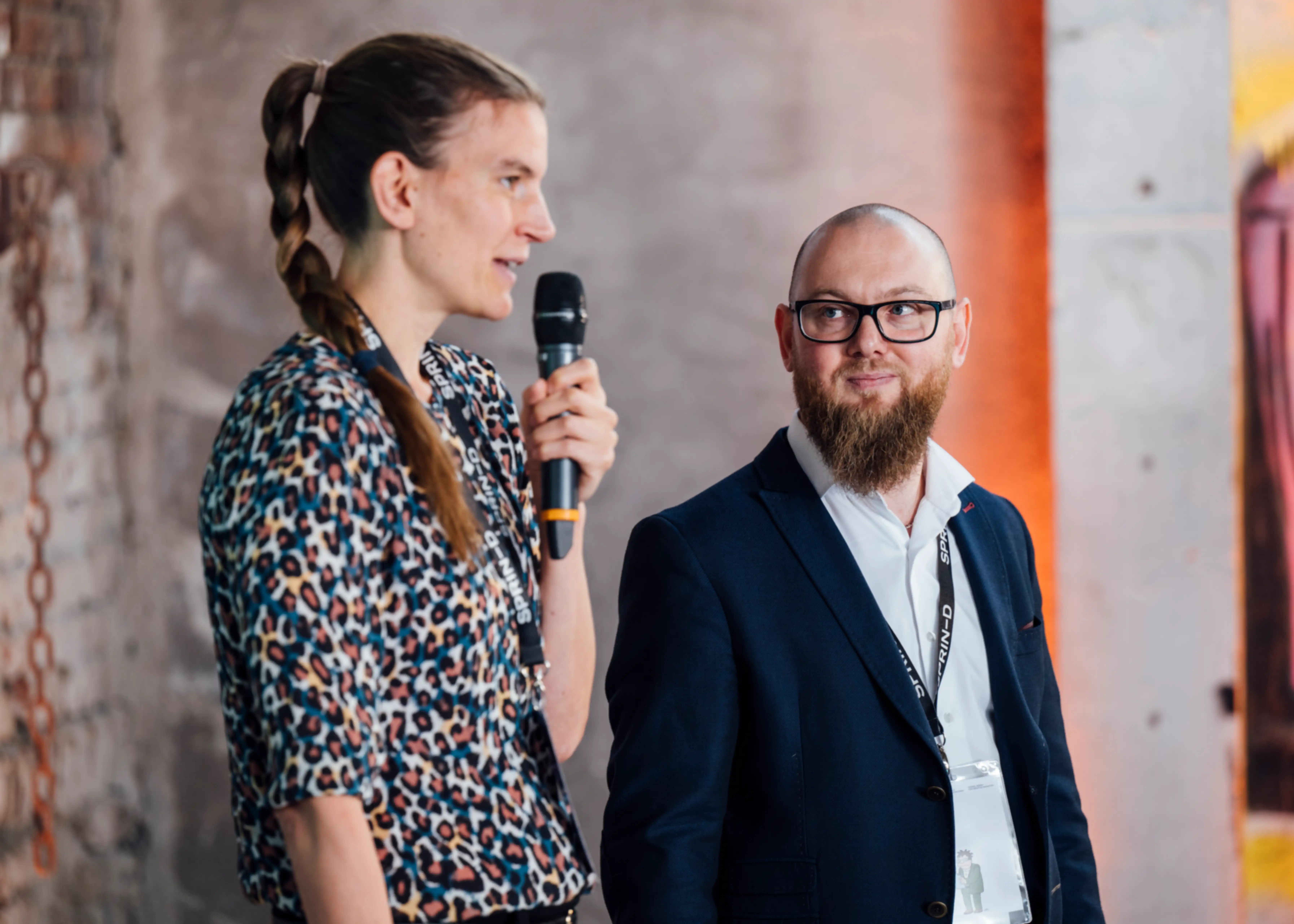 One person is giving a presentation; another is standing next to them