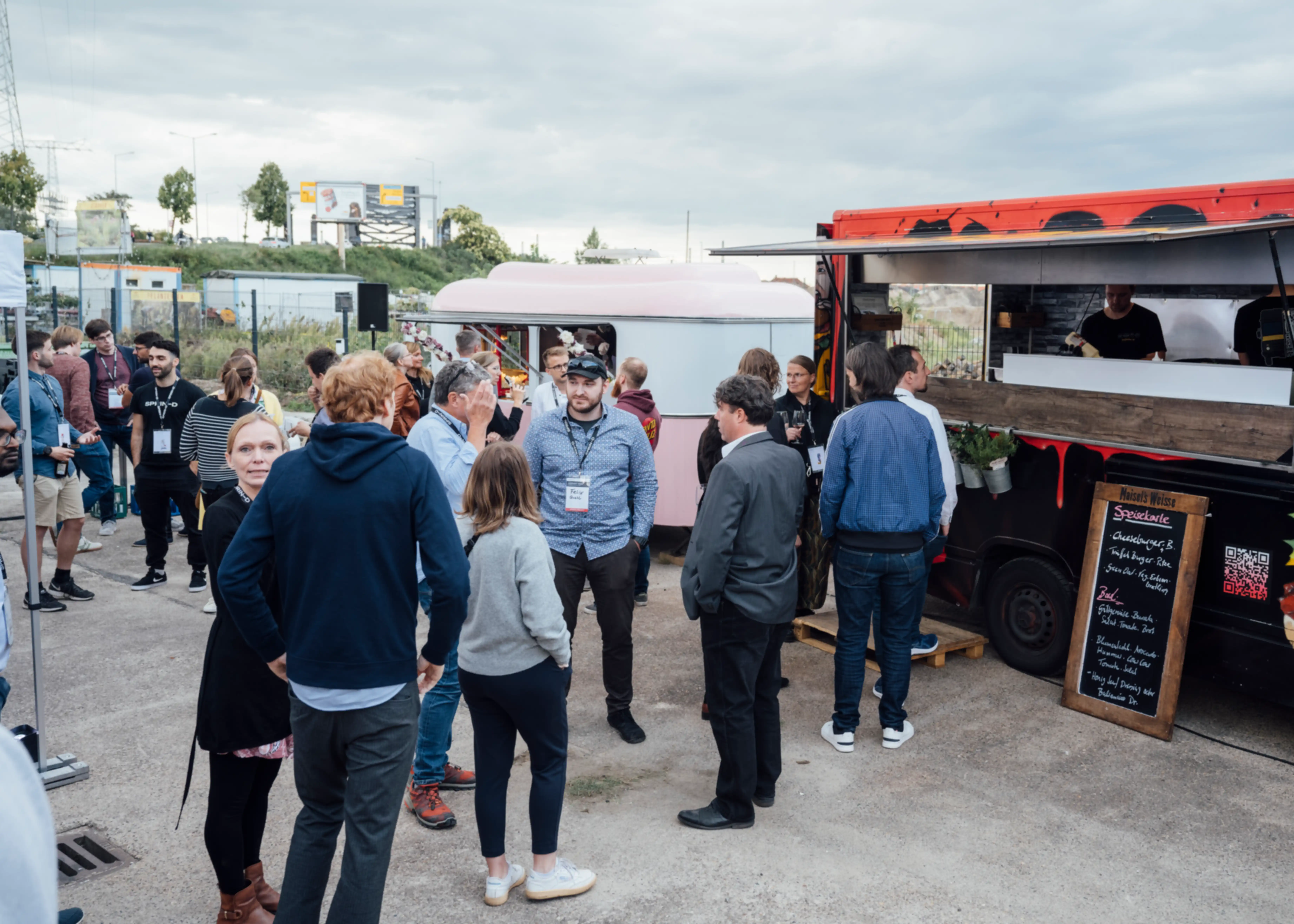 Several people waiting in line in front of a food truck